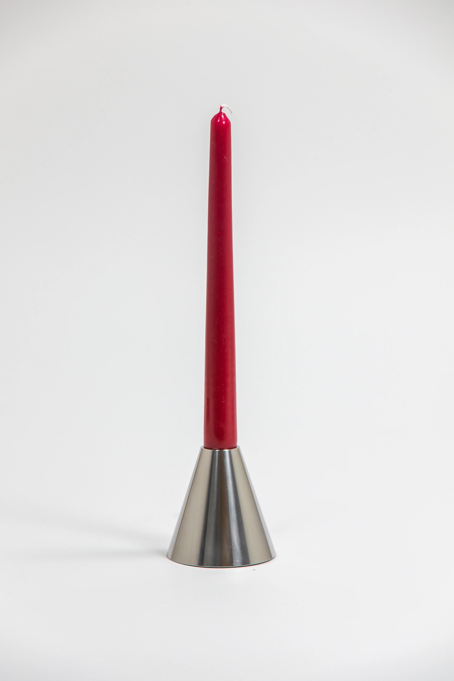 Conic candlestick holder with a red taper candle